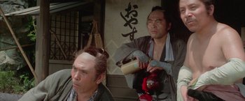 Movie still from “Lone Wolf and Cub: Baby Cart to Hades” (1972), directed by Kenji Misumi – Two men in traditional asian garb , one of which is holding a drink; Medium shot, Over the shoulder angle