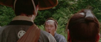 Movie still from “Lone Wolf and Cub: Baby Cart to Hades” (1972), directed by Kenji Misumi – A man with a bandage on his head is looking surprised; Close Up shot, Over the shoulder angle