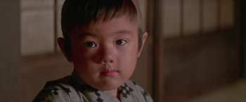 Movie still from “Lone Wolf and Cub: Baby Cart to Hades” (1972), directed by Kenji Misumi – A young boy with a checkered shirt; Close Up shot, High angle