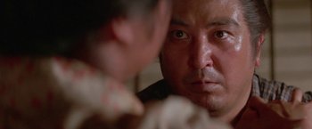 Movie still from “Lone Wolf and Cub: Baby Cart to Hades” (1972), directed by Kenji Misumi – A person looking at a mirror; Close Up shot, Over the shoulder angle