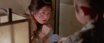 Movie still from “Lone Wolf and Cub: Baby Cart to Hades” (1972), directed by Kenji Misumi – A woman looking in a mirror with a scarf on; Close Up shot, High angle