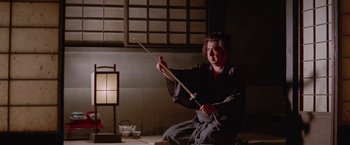 Movie still from “Lone Wolf and Cub: Baby Cart to Hades” (1972), directed by Kenji Misumi – A person holding a sword in a room; Medium shot, Low angle