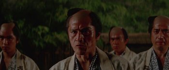 Movie still from “Lone Wolf and Cub: Baby Cart to Hades” (1972), directed by Kenji Misumi – An older man with a bald head is looking at the camera; Close Up shot, Low angle