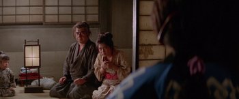 Movie still from “Lone Wolf and Cub: Baby Cart to Hades” (1972), directed by Kenji Misumi – A man and a woman sitting next to each other; Medium shot, Over the shoulder angle