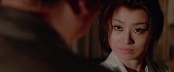 Movie still from “Lone Wolf and Cub: Baby Cart to Hades” (1972), directed by Kenji Misumi – A woman's face and a man's reflection in a mirror; Close Up shot, Over the shoulder angle