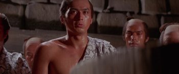 Movie still from “Lone Wolf and Cub: Baby Cart to Hades” (1972), directed by Kenji Misumi – A man with a towel around his neck and shoulders; Close Up shot, Low angle