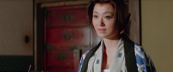 Movie still from “Lone Wolf and Cub: Baby Cart to Hades” (1972), directed by Kenji Misumi – A woman in a kimono is standing in front of a cabinet; Close Up shot, Low angle