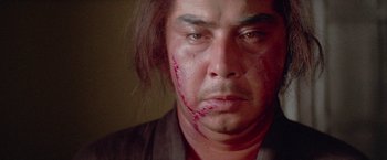 Movie still from “Lone Wolf and Cub: Baby Cart to Hades” (1972), directed by Kenji Misumi – A person with blood on his face; Close Up shot, Low angle