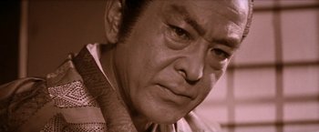 Movie still from “Lone Wolf and Cub: Baby Cart to Hades” (1972), directed by Kenji Misumi – An older man with a serious look on his face; Close Up shot, Low angle
