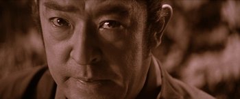 Movie still from “Lone Wolf and Cub: Baby Cart to Hades” (1972), directed by Kenji Misumi – A man's face in sepia tone; Extreme Close Up shot, Low angle