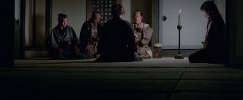 Movie still from “Lone Wolf and Cub: Baby Cart to Hades” (1972), directed by Kenji Misumi – A group of people sitting on a floor; Wide shot, High angle