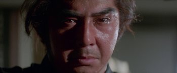 Movie still from “Lone Wolf and Cub: Baby Cart to Hades” (1972), directed by Kenji Misumi – A person's face in a dark room; Extreme Close Up shot, Low angle