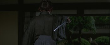 Movie still from “Lone Wolf and Cub: Baby Cart to Hades” (1972), directed by Kenji Misumi – A person holding a sword in their hand; Close Up shot, Over the shoulder angle