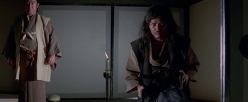 Movie still from “Lone Wolf and Cub: Baby Cart to Hades” (1972), directed by Kenji Misumi – A man sitting in front of a lit candle; Medium shot, High angle