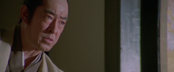 Movie still from “Lone Wolf and Cub: Baby Cart to Hades” (1972), directed by Kenji Misumi – An older asian man looking at the camera; Close Up shot, Low angle