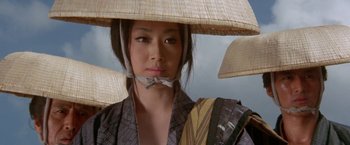 Movie still from “Lone Wolf and Cub: Baby Cart to Hades” (1972), directed by Kenji Misumi – A woman in a kimono with a hat on her head; Close Up shot, Low angle
