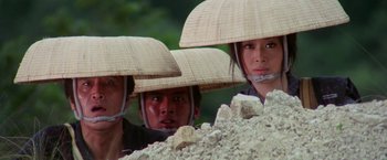 Movie still from “Lone Wolf and Cub: Baby Cart to Hades” (1972), directed by Kenji Misumi – A group of people wearing hats on top of a pile of rocks; Close Up shot, Low angle