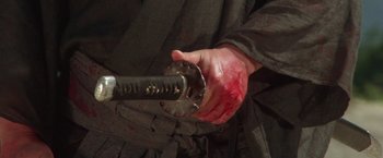 Movie still from “Lone Wolf and Cub: Baby Cart to Hades” (1972), directed by Kenji Misumi – A man holding a knife with blood on it; Extreme Close Up shot, High angle