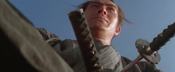 Movie still from “Lone Wolf and Cub: Baby Cart to Hades” (1972), directed by Kenji Misumi – A man holding a sword up to the sky; Close Up shot, Low angle