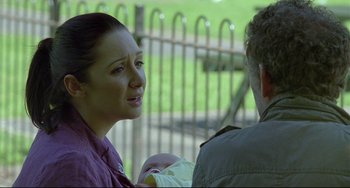 Movie still from “Looking for Eric” (2009), directed by Ken Loach – A woman holding a baby in her arms while talking to an older man; Close Up shot, Over the shoulder angle