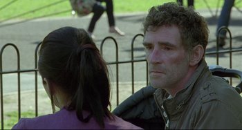 Movie still from “Looking for Eric” (2009), directed by Ken Loach – A person sitting next to another person; Medium shot, Over the shoulder angle
