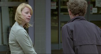 Movie still from “Looking for Eric” (2009), directed by Ken Loach – A woman standing next to a man on a sidewalk; Medium shot, Over the shoulder angle