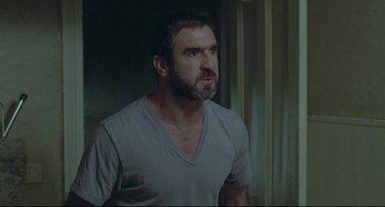 Movie still from “Looking for Eric” (2009), directed by Ken Loach – A person wearing a shirt; Medium shot, Over the shoulder angle
