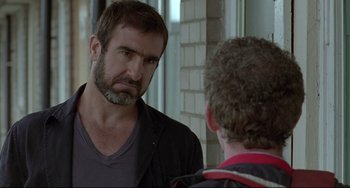 Movie still from “Looking for Eric” (2009), directed by Ken Loach – A man looking at another man in the mirror; Close Up shot, Over the shoulder angle