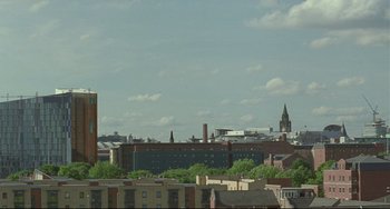 Movie still from “Looking for Eric” (2009), directed by Ken Loach – A view of a city skyline from a distance; Extreme Wide shot, High angle