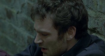 Movie still from “Looking for Eric” (2009), directed by Ken Loach – A person wearing a black jacket; Close Up shot, High angle