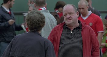 Movie still from “Looking for Eric” (2009), directed by Ken Loach – A man in a red jacket talking to another man in a black shirt; Medium shot, Over the shoulder angle