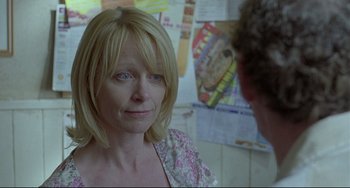 Movie still from “Looking for Eric” (2009), directed by Ken Loach – A woman with blonde hair and blue eyes talking to a man; Close Up shot, Over the shoulder angle
