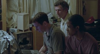 Movie still from “Looking for Eric” (2009), directed by Ken Loach – A group of people that are looking at something on a computer; Medium shot, High angle