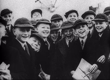 Movie still from “Lord of the Flies” (1963), directed by Peter Brook – A group of young boys wearing hats and smiling; Close Up shot, High angle