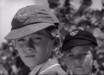 Movie still from “Lord of the Flies” (1963), directed by Peter Brook – Two young boys wearing hats in a black and white photo; Close Up shot, Low angle