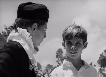 Movie still from “Lord of the Flies” (1963), directed by Peter Brook – Two young men are standing next to each other; Close Up shot, Over the shoulder angle