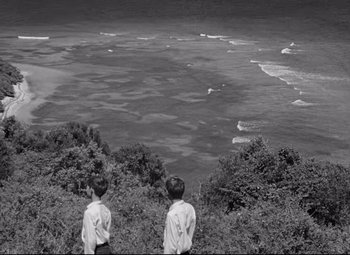 Movie still from “Lord of the Flies” (1963), directed by Peter Brook – Two young boys looking out over the ocean; Extreme Wide shot, High angle