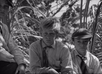 Movie still from “Lord of the Flies” (1963), directed by Peter Brook – A black and white photo of three young men; Medium shot, Low angle