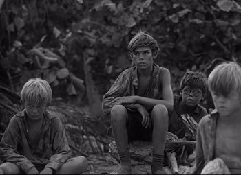 Movie still from “Lord of the Flies” (1963), directed by Peter Brook – A group of young men sitting on top of a tree; Medium shot, High angle