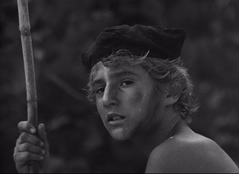 Movie still from “Lord of the Flies” (1963), directed by Peter Brook – A young man holding a wooden stick in his hand; Close Up shot, High angle