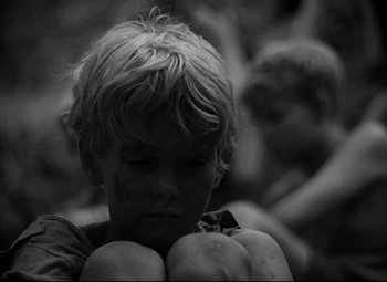 Movie still from “Lord of the Flies” (1963), directed by Peter Brook – Black and white photograph of a young boy holding apples; Close Up shot, High angle