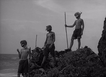 Movie still from “Lord of the Flies” (1963), directed by Peter Brook – A group of people standing on top of a hill; Wide shot, Low angle