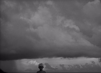 Movie still from “Lord of the Flies” (1963), directed by Peter Brook – A person standing in front of a cloudy sky; Extreme Wide shot, Low angle