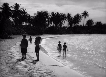 Movie still from “Lord of the Flies” (1963), directed by Peter Brook – A black and white photo of a group of people on the beach; Extreme Wide shot, High angle