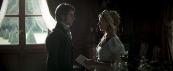 Movie still from “Lost Illusions” (2021), directed by Xavier Giannoli – A man and a woman standing next to each other holding papers; Medium shot, Over the shoulder angle