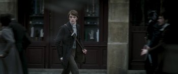 Movie still from “Lost Illusions” (2021), directed by Xavier Giannoli – A man in a suit and tie walking down the street; Medium shot, Low angle