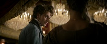 Movie still from “Lost Illusions” (2021), directed by Xavier Giannoli – A young man standing in front of a chandelier; Close Up shot, Over the shoulder angle