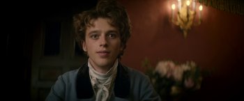 Movie still from “Lost Illusions” (2021), directed by Xavier Giannoli – A young man in a blue jacket is looking at the camera; Close Up shot, Over the shoulder angle