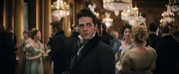 Movie still from “Lost Illusions” (2021), directed by Xavier Giannoli – A man in a black jacket and a white neck tie; Medium shot, Over the shoulder angle