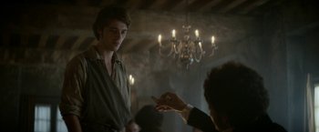 Movie still from “Lost Illusions” (2021), directed by Xavier Giannoli – A young man is holding something in his hand; Medium shot, Over the shoulder angle